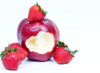 Fresh strawberries with a bitten wet red apple.