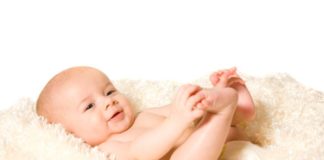 Baby on fluffy cream colored blanket.