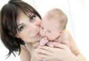 Close up shot of dark haired woman with small baby.